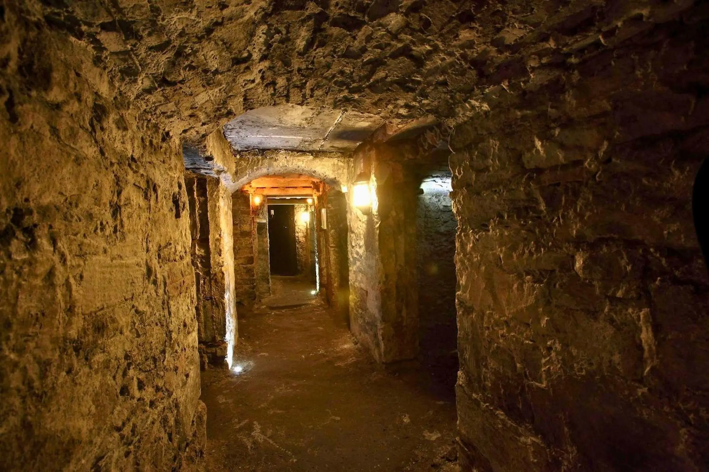 A dimly lit stone archway inside the Blair Street Underground Vaults